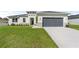 Single-story home with gray garage door and well-manicured lawn at 3425 Dryden St, North Port, FL 34288