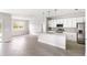 Open kitchen with island, stainless steel appliances, and white cabinets at 3425 Dryden St, North Port, FL 34288