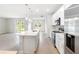 Open kitchen with island, stainless steel appliances, and white cabinets at 3425 Dryden St, North Port, FL 34288