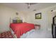 Comfortable bedroom with a ceiling fan, tile floor and red accents at 3663 Muirfield Dr # 4B, Sarasota, FL 34238