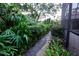 A stone path winds through a lush, green garden landscape at 3947 Country View Dr, Sarasota, FL 34233