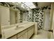 Bathroom with a large vanity, bathtub, and tropical-themed wallpaper at 3947 Country View Dr, Sarasota, FL 34233