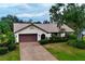 Single-story house with brown garage door and landscaped lawn at 3947 Country View Dr, Sarasota, FL 34233
