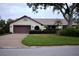 Single-story house with brown garage door and neat landscaping at 3947 Country View Dr, Sarasota, FL 34233