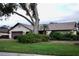 Single-story home with mature landscaping and attached garage at 3947 Country View Dr, Sarasota, FL 34233
