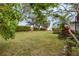 Spacious backyard with lush lawn and mature trees at 404 Bayside Ln, Nokomis, FL 34275