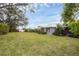 Large backyard with a view of the house and lush landscaping at 404 Bayside Ln, Nokomis, FL 34275
