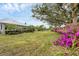Green grassy backyard, partially shaded, featuring colorful flowers at 404 Bayside Ln, Nokomis, FL 34275