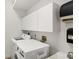 Laundry room with washer, dryer, cabinets, and utility sink at 404 Bayside Ln, Nokomis, FL 34275