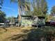 Green house with a wooden deck and additional outbuilding at 4122 N Lockwood Ridge Rd, Sarasota, FL 34234