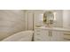 Spa-like bathroom with freestanding tub, marble walls, and gold accents at 415 L Ambiance Dr # C204, Longboat Key, FL 34228