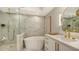 Elegant bathroom featuring a walk-in shower, freestanding tub and marble tile at 415 L Ambiance Dr # C204, Longboat Key, FL 34228