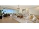 Living room boasts hardwood floors, sectional sofa, and sliding glass doors leading to balcony with ocean view at 415 L Ambiance Dr # C204, Longboat Key, FL 34228