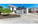 Modern home exterior with a detached garage and landscaped yard at 5613 Gulf Dr, Holmes Beach, FL 34217