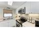 Updated kitchen with white cabinets and granite countertops at 5613 Gulf Dr, Holmes Beach, FL 34217
