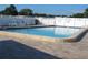 Sparkling community pool with lounge chairs and fencing at 5619 Bayshore Rd # 115, Palmetto, FL 34221