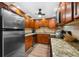 Well-equipped kitchen with wood cabinets, granite counters, and stainless steel appliances at 5855 Midnight Pass Rd # 311, Sarasota, FL 34242