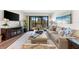Relax in this living room featuring a plush sofa and access to a balcony at 5855 Midnight Pass Rd # 311, Sarasota, FL 34242