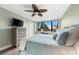 Main bedroom with king-size bed, hardwood floors, and ceiling fan at 5855 Midnight Pass Rd # 311, Sarasota, FL 34242