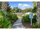 Attractive walkway to home, lush landscaping, and community sign at 5916 Bonaventure Pl, Sarasota, FL 34243