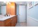 Bathroom with light wood cabinets, a single sink, and a door at 6300 Midnight Pass Rd # 708, Sarasota, FL 34242