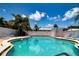 Relaxing kidney-shaped pool with lounge chairs and palm trees at 6300 Midnight Pass Rd # 708, Sarasota, FL 34242