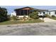 Front view of a manufactured home with mature landscaping at 763 Lakeside Dr, North Port, FL 34287