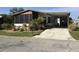 Single-wide manufactured home with carport, landscaped yard, and screened porch at 763 Lakeside Dr, North Port, FL 34287
