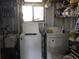 Small laundry room with washer, dryer, and storage shelves at 763 Lakeside Dr, North Port, FL 34287