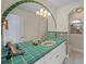 Bright bathroom with a unique sink, green tile, and arched mirror at 929 Casey Cove Dr, Nokomis, FL 34275