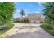 Front view of a two-story home with a circular driveway and lush landscaping at 929 Casey Cove Dr, Nokomis, FL 34275