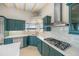 Modern kitchen with teal cabinets and gas cooktop at 929 Casey Cove Dr, Nokomis, FL 34275