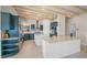 Modern kitchen with teal cabinets, island, and stainless steel appliances at 929 Casey Cove Dr, Nokomis, FL 34275