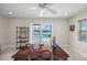 Home office with water view, large windows and a wooden desk at 929 Casey Cove Dr, Nokomis, FL 34275