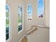 Bright stairwell with arched windows and wood railing at 929 Casey Cove Dr, Nokomis, FL 34275