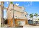 Tan three-story house with a white garage door and palm trees at 107 75Th St, Holmes Beach, FL 34217