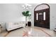 Bright entry with tile floors, white sofa, and elegant double doors at 1450 Bern Creek Loop, Sarasota, FL 34240