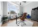 Bright home office with a view, featuring a standing desk and comfortable chair at 1450 Bern Creek Loop, Sarasota, FL 34240