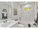 Clean bathroom with white vanity, bathtub, and marble tile at 1463 Jinright Rd, North Port, FL 34288
