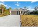 New construction home with a two-car garage and landscaped lawn at 1463 Jinright Rd, North Port, FL 34288