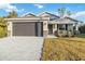 New construction home with a two-car garage and landscaped lawn at 1463 Jinright Rd, North Port, FL 34288