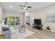 Bright living room with hardwood floors, ceiling fan, and sliding glass doors at 1463 Jinright Rd, North Port, FL 34288