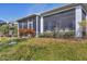 Landscaped backyard with screened porch and lush greenery at 1570 Monarch Dr, Venice, FL 34293