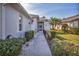 Pathway to the front entrance, featuring landscaping and a screened porch at 1570 Monarch Dr, Venice, FL 34293