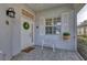 Front porch with white door, wreath, and a decorative bench at 1570 Monarch Dr, Venice, FL 34293