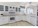 White kitchen with stainless steel appliances and granite countertops at 1570 Monarch Dr, Venice, FL 34293
