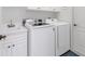 White cabinets and a clean laundry room with washer and dryer at 1570 Monarch Dr, Venice, FL 34293