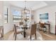 Bright dining room with a glass-top table and view to golf course at 17108 Vardon Ter # 203, Lakewood Ranch, FL 34211