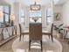Bright dining room with a glass table and four chairs, complemented by a large window at 17108 Vardon Ter # 203, Lakewood Ranch, FL 34211