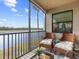 Peaceful screened lanai with wicker furniture and water views at 17108 Vardon Ter # 203, Lakewood Ranch, FL 34211